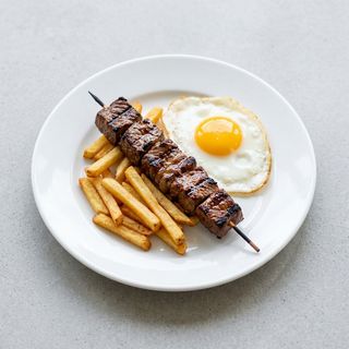 Pincho marinado con patatas fritas y huevo
