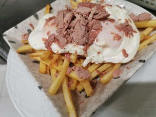 Huevos con patatas fritas y virutas de foie