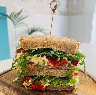 Sándwich de hummus, aguacate, tomate y rúcula