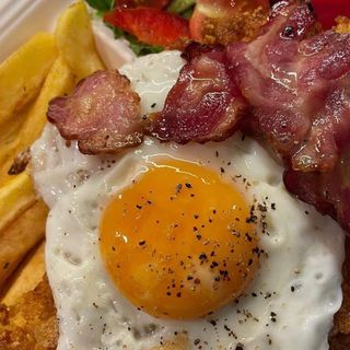 Chrupiący kurczak z jajkiem sadzonym i bekonem z frytkami i sałatką