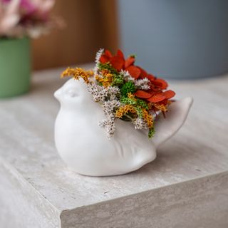 Pássaro pequeno branco com flores vermelhas