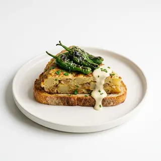 Tosta de tortilla de patatas, pimientos de padrón y salsa alioli