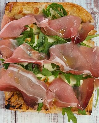 Focaccia con speck, rúcula y aceite de ajo