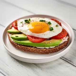 Tostada aguacate, queso crema, tomate y huevo