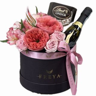 Cutie medie cu flori roz, spumant si ciocolată