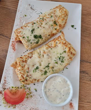 Naleśniki z farszem pieczarkowym , żółtym serem i sosem czosnkowym