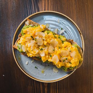 Tostada De Aguacate Con huevos revueltos y parmesano