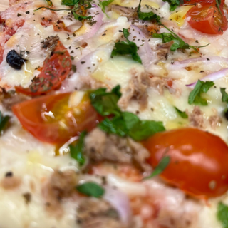 Porción de pizza de atún, cebolla roja, cherrys y aceitunas negras 