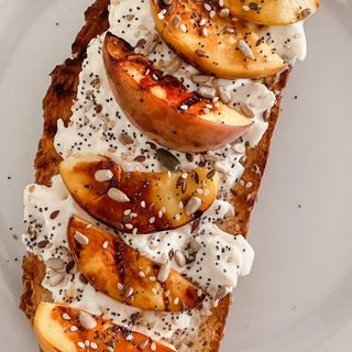 Tostada de queso crema y melocotón natural con miel y frutos secos 