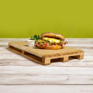 Egg benedict bagel servito con rucola e salsa senape e miele