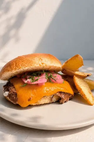 Cordero desilachado con salsa de yogurt, queso chédar y brioche