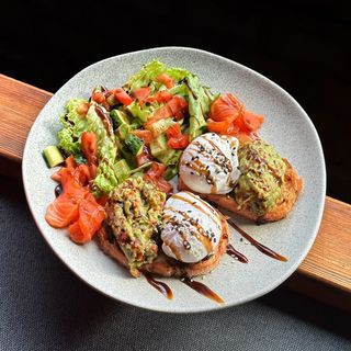 Яйця пашот на тостах з лососем, гуакамоле і салатом