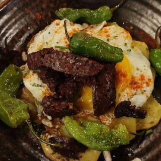 Huevos Rotos Con Butifarra Negra Y Pimientos De Padrón