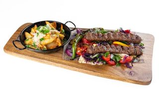 Kebab Adana servit cu legume coapte sos de ardei lipie si cartofi prajiti