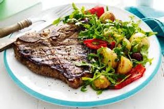 Grilled T Bone Steak Served With Roast Potatoes