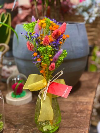 Botella con flor seca muy colorida. 