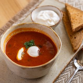 Солянка м'ясна зі скибкою лимона, оливкою та грінками