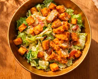 Ensalada cesar de pollo Karaage con bacon y grana padano