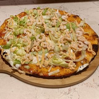 Pizza tonda rossa con mozzarella, insalata, gamberetti e salsa rosa