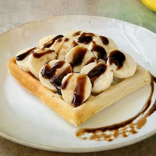 Pola porcije waffli  sa Nutellom, slatkim bananama i sladoledom