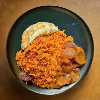 Jollof rice, pan fried egg and peppered pomo