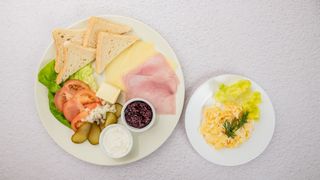 Zestaw śniadaniowy (pieczywo, masło, ogórek świeży, pomidor, cebulka, wędlina, ser, twaróg, dżem, jajecznica na maśle z dwóch jajek)