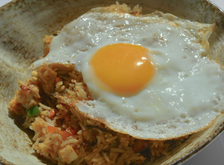 Arroz frito con pollo braseado, verduras y huevo plancha