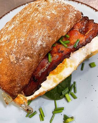 Ciabatta pełnoziarnista z jajkiem sadzonym bekonem i szpinakiem