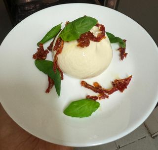 Burrata con pomodorini secchi, basilico e olio Evo