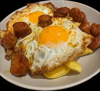 Huevos rotos con patatas y txorizo, morcilla, o jamón ibérico 