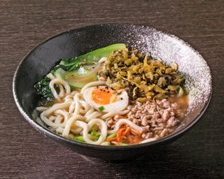 Noodles in brodo con tubero di senape, carne macinata e uova