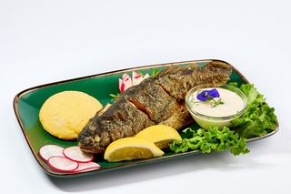 Păstrăv prăjit cu mămăligă și sos de iaurt sau usturoi