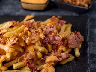 Картопля фрі з смаженою цибулею та беконом