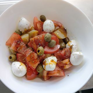 Insalata di patate con mozzarella, pomodori e olive.