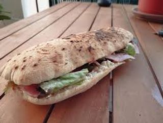 Panino di pizza con pomodoro fresco, insalata e prosciutto cotto