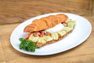 Круасан з баварськими ковбасками та яйцем пашот