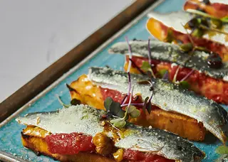 Sardine marinate sobre focaccia pomodoro y vinagreta de frutos s