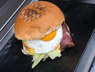 Panino con hamburger, cheddar, bacon, insalata e uova