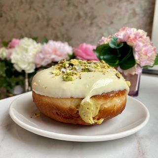 Pączek pistacja/polewa z białej czekolady