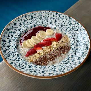 Мультизлакова каша з арахісовою пастою, сезонними ягодами, кюлі та бананом 