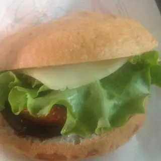 Panino vegano con burger di verdure, verdure grigliate, cipolle, olive