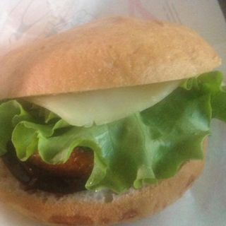 Panino vegano con burger di verdure, verdure grigliate, cipolle, olive