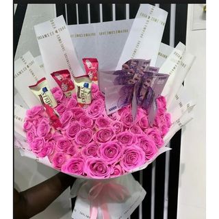 Hand bouquet of pink roses with chocolates and cash