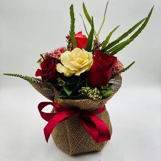 Pot fiorito con fiori bianchi e rossi e fiocco rosso