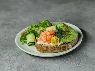 Хрусткий тост з лососем, авокадо, огірками та томатами чері