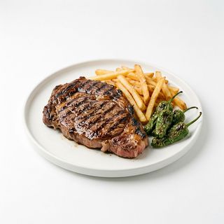 Entrecot de vaca con patatas fritas y pimientos de padrón