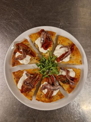 Stracciatella di burrata , filetti di acciughe e pomodori secchi