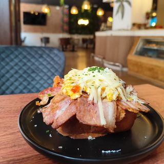 Tosta de bacon, huevo revuelto, queso gruyere y cebollín