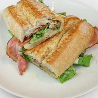 BOCADILLO ÑAM: Pollo a la parrilla con salsa de queso, cebolla caramelizada, beicon crujiente y vegetales (Mezcla de lechugas)