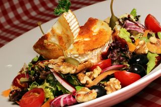 Ensalada gourmet con queso de cabra tostado salsa de frutas del bosque